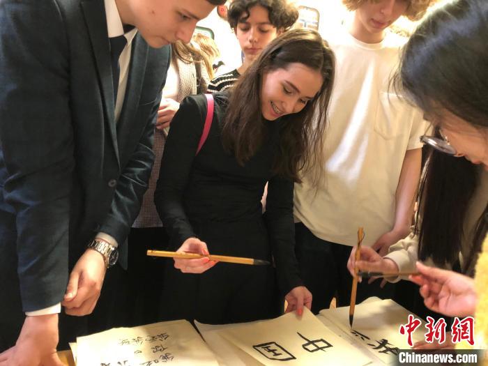 4月21日，莫斯科國立語言大學孔子學院附屬中學舉辦“國際中文日”活動，學生們學寫漢字。　莫斯科國立語言大學孔子學院 供圖