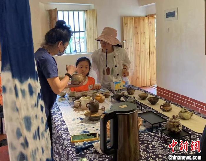 圖為：游客正在咨詢臺灣柴燒作品。　葉秋云 攝