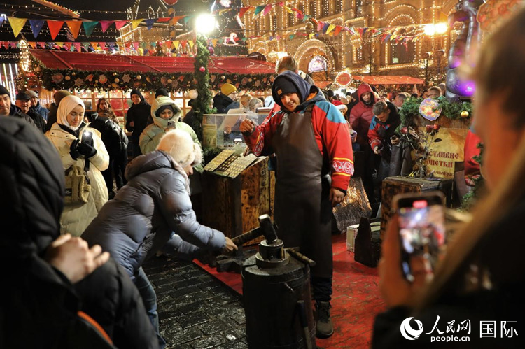 游客在新年集市上體驗制作紀(jì)念幣。人民網(wǎng)記者 隋鑫攝