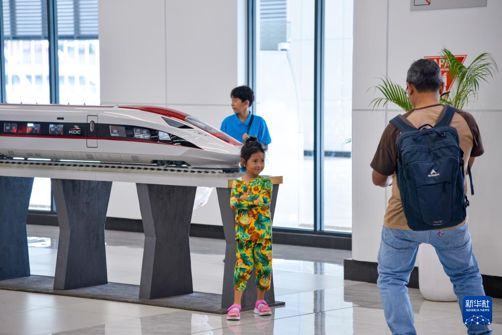 1月24日，在印度尼西亞雅加達(dá)哈利姆站候車大廳，一名小朋友和雅萬高鐵高速動車組模型合影。新華社記者 徐欽 攝