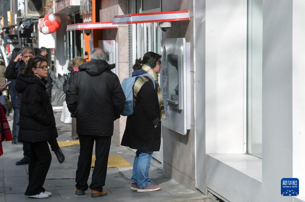 1月25日，人們在土耳其安卡拉一處銀行自動柜員機前辦理業(yè)務。新華社發(fā)（穆斯塔法·卡亞攝）