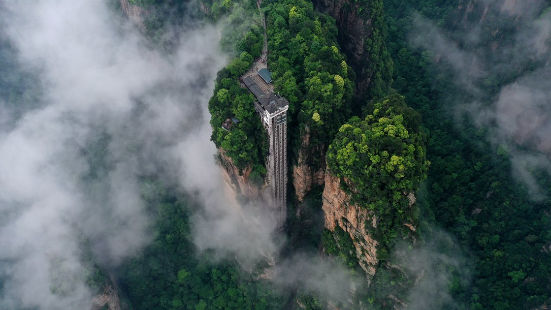 位于張家界武陵源景區(qū)的百龍?zhí)焯蓁偳对谠旗F繚繞的峰林間，雄偉壯觀。吳勇兵攝