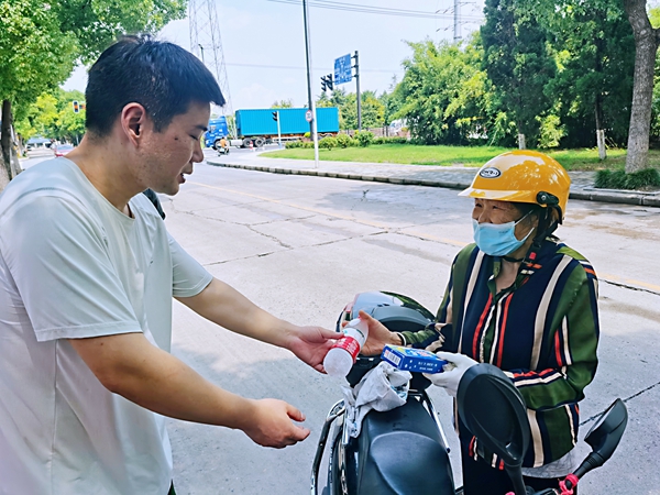 何超為過路的老人送上礦泉水和冷飲。人民網(wǎng)記者 王繼亮攝