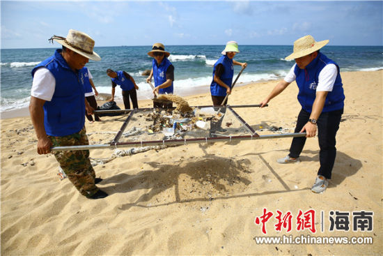 環(huán)保志愿者用篩網(wǎng)“淘”出海灘上的垃圾。