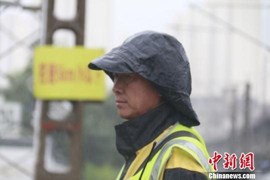蘭州西工務(wù)段蘭州線路車(chē)間防護(hù)員雨中巡查?！⊥豕廨x 攝