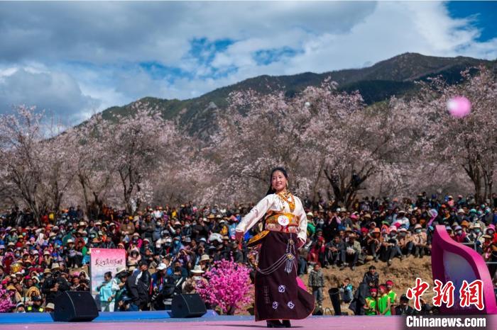 桃花林下精彩的“桃花仙子”選拔吸引村民或游客。　劉忠俊 攝