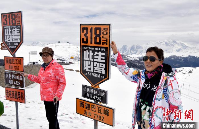 圖為5月14日，西藏林芝色季拉山觀景臺，游客與南迦巴瓦峰合影?！±盍?攝