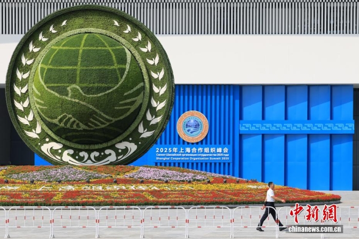8月31日，天津，一名工作人員從2025年上海合作組織峰會(huì)主會(huì)場外的景觀花壇旁經(jīng)過。當(dāng)日，2025年上海合作組織峰會(huì)在天津舉行。<a target='_blank' href='/'><p  align=