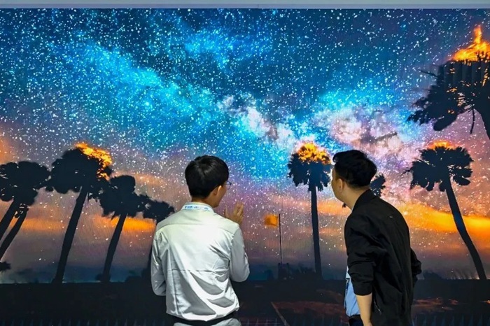 長春光博會希達電子展區(qū)，一位工作人員正在給一位觀眾講解。（長春新區(qū)供圖）