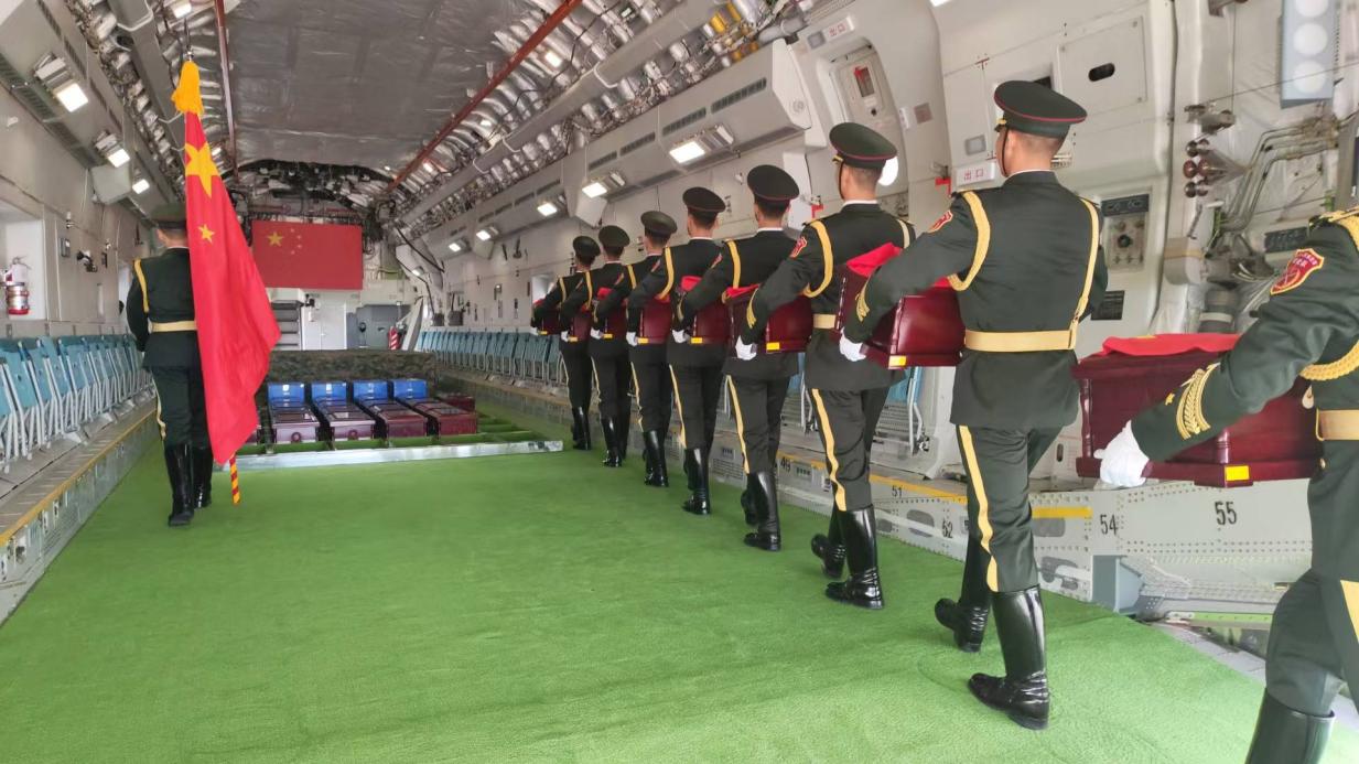 在韓國仁川國際機(jī)場，引靈手徐澤東引領(lǐng)中國人民解放軍儀仗司禮大隊禮兵護(hù)送英烈遺骸棺槨登上空軍“運(yùn)-20”專機(jī)啟程回國?？照麄骶止﹫D