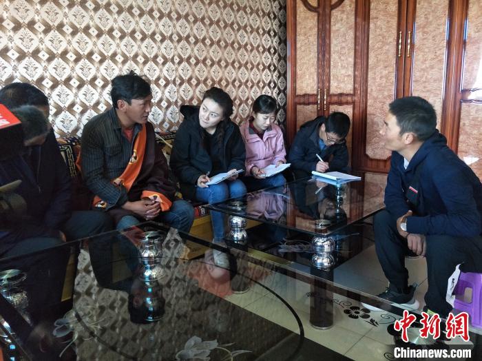 圖為調(diào)查組工作人員正在入戶調(diào)查。　祁增蓓 攝