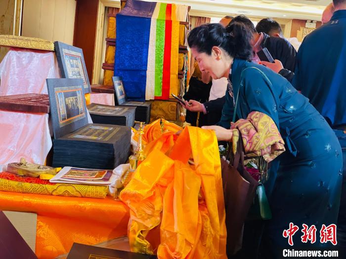 圖為現(xiàn)場藏族民眾向黃金書寫的大藏經(jīng)《甘珠爾》敬獻哈達?！O睿 攝