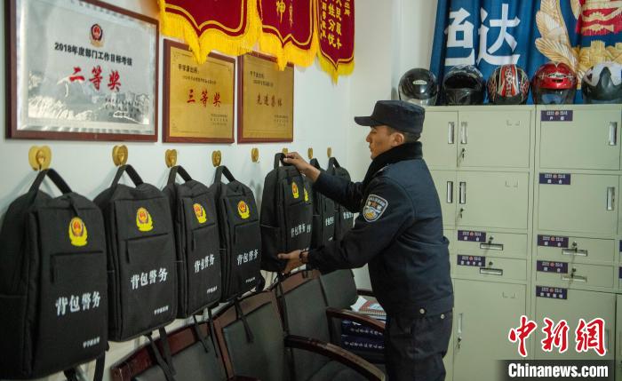 甲學(xué)鎮(zhèn)派出所值班室，8個(gè)“警務(wù)背包”掛在墻上依次排開(kāi) 劉忠俊 攝