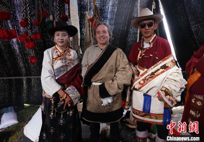 圖為一名外籍攝影師(中)身穿藏服和藏族民眾合影留念?！●R銘言 攝