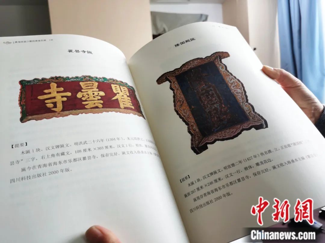 古籍保護人員展示介紹明代朱元璋撰寫的青海瞿曇寺匾(左)的出版書籍。張?zhí)砀?攝