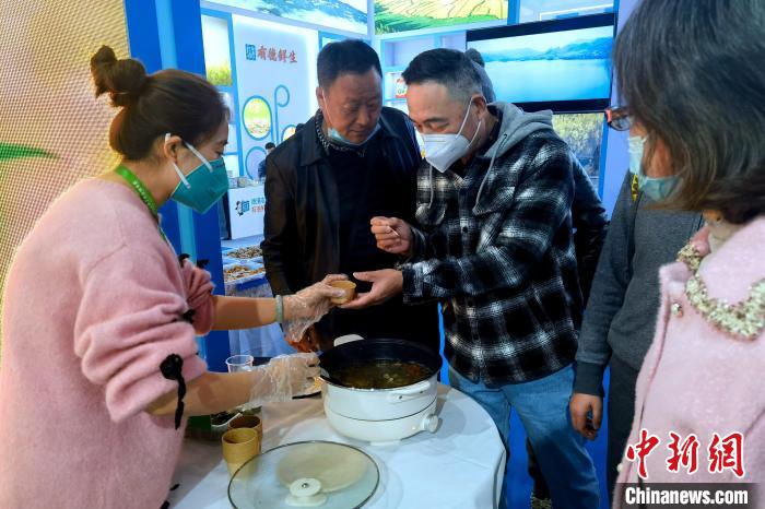 圖為杭州市民品嘗茶卡羊肉?！±铍h 攝