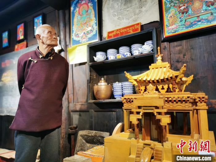 圖為古堡內的藝人桑杰展示自己的雕刻作品?！?zhí)砀?攝