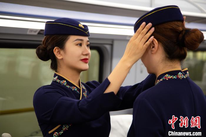 圖為青藏鐵路西格段“復興號”動車組乘務員互相整理新制服?！±罾?攝
