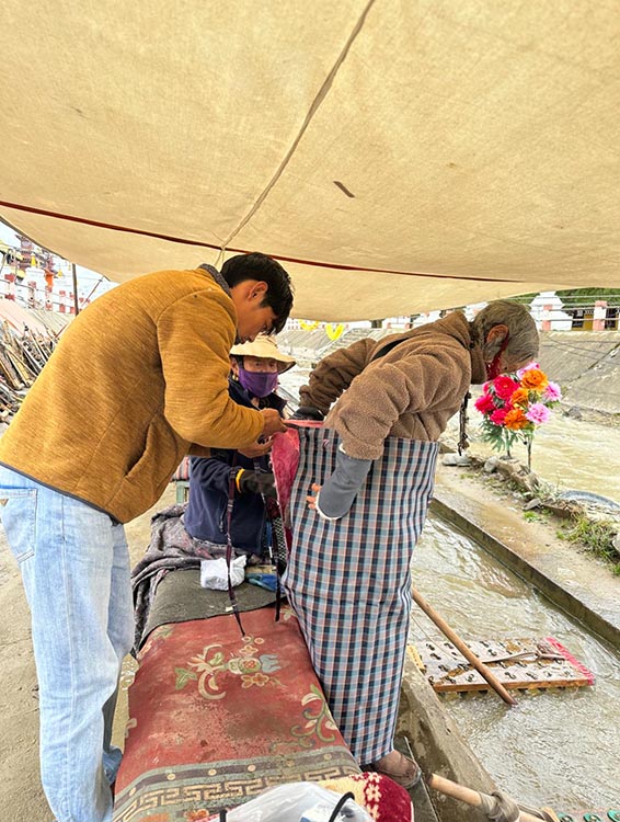 扎西奪爾登為路邊老人送去保暖圍腰。阿壩州文明辦供圖
