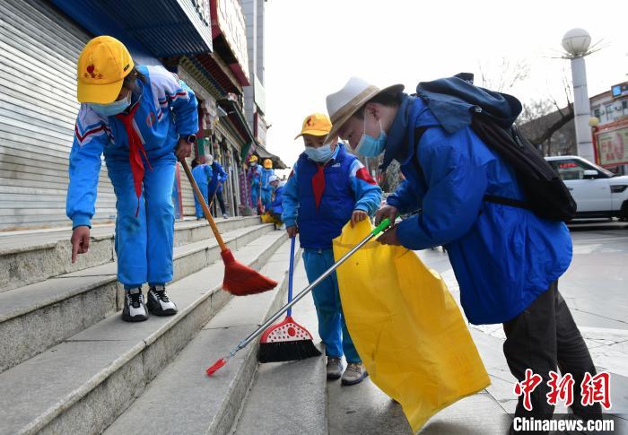 圖為拉薩市小學生打掃街道?！∝暩聛硭?攝
