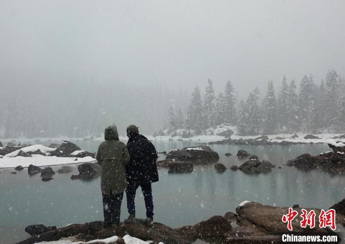 游客欣賞雪中然烏湖。　冉文娟 攝