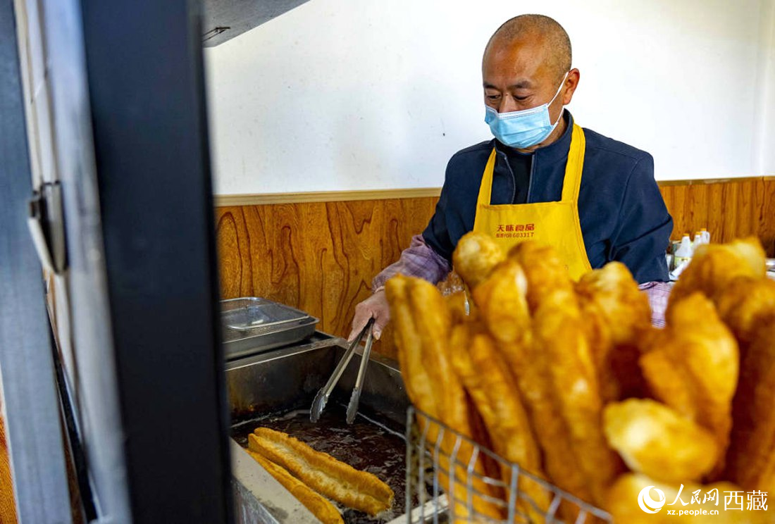 早餐店老板正在炸油條。人民網(wǎng) 次仁羅布攝